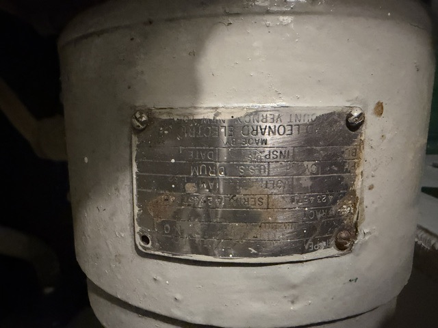 Leonard Electric builder's nameplate documented aboard USS Alabama (BB-60) — Close-up of an electric motor's builder's nameplate reading 'Made by Leonard Electric, Mount Vernon' with serial and type ('DRUM') data, mounted on a grey-painted cylindrical motor housing aboard USS Alabama.